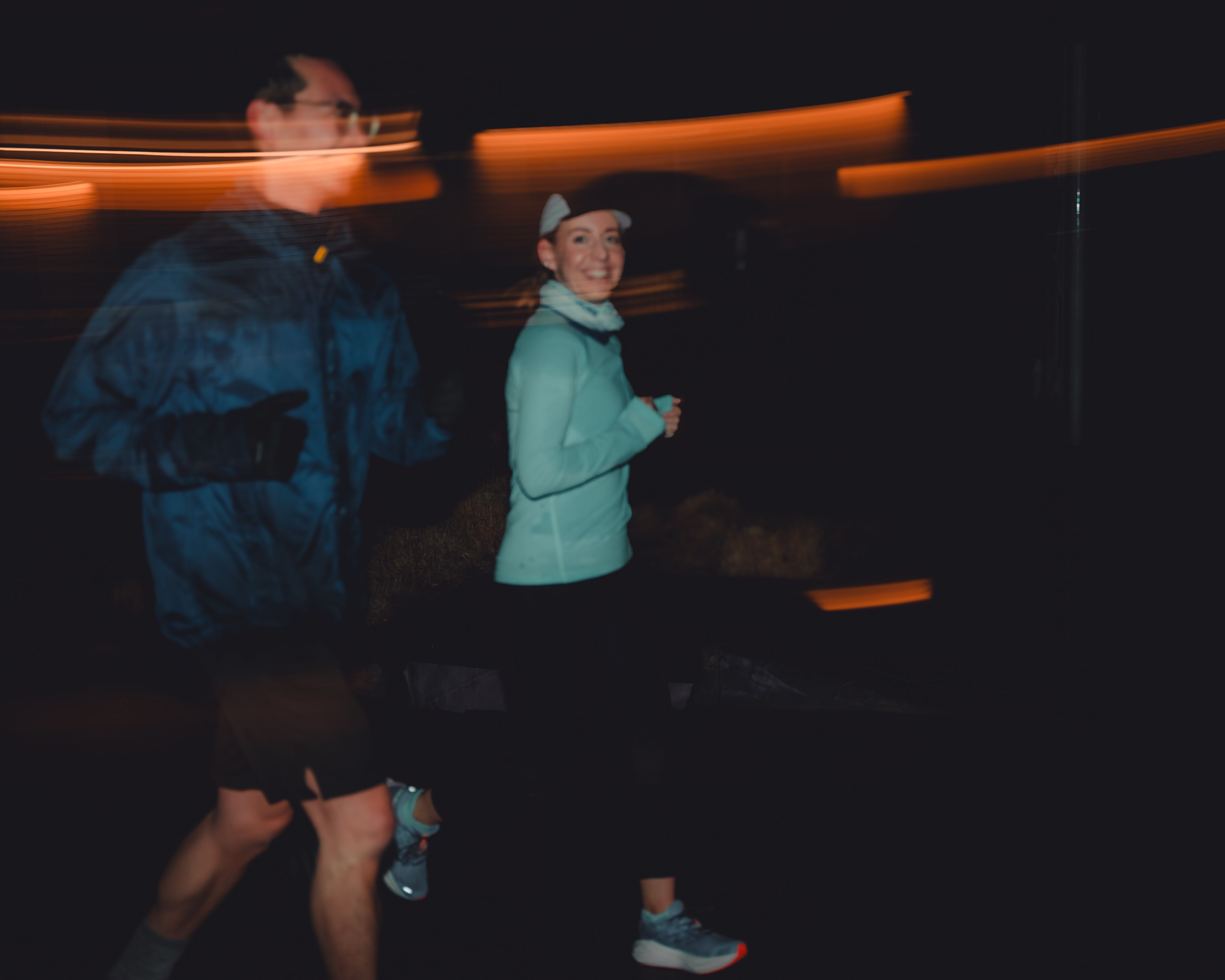 female runner smiling while running with another person